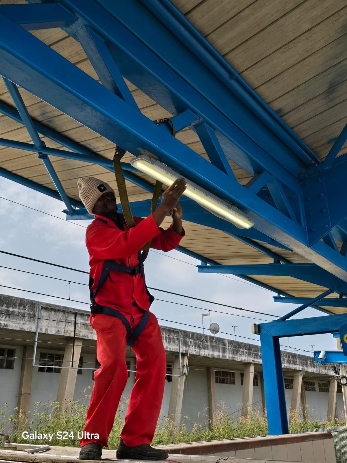 Amabanzi technician installing platform lighting